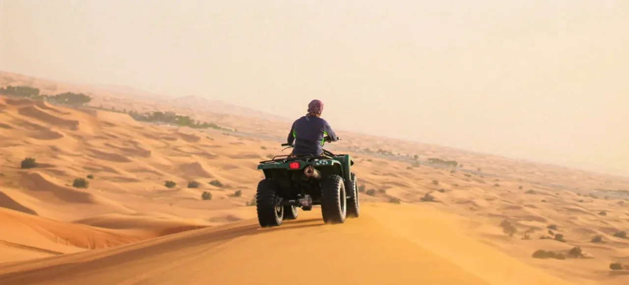 Quad bike riding over sand dunes