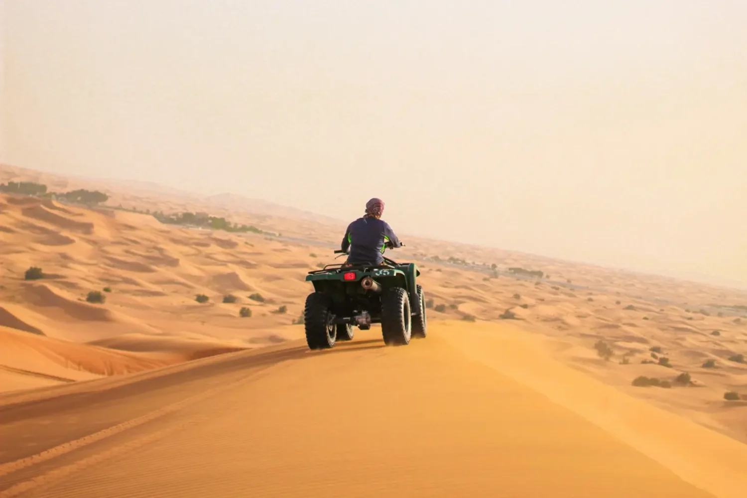 Quad bike riding over sand dunes