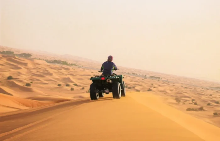Quad bike riding over sand dunes