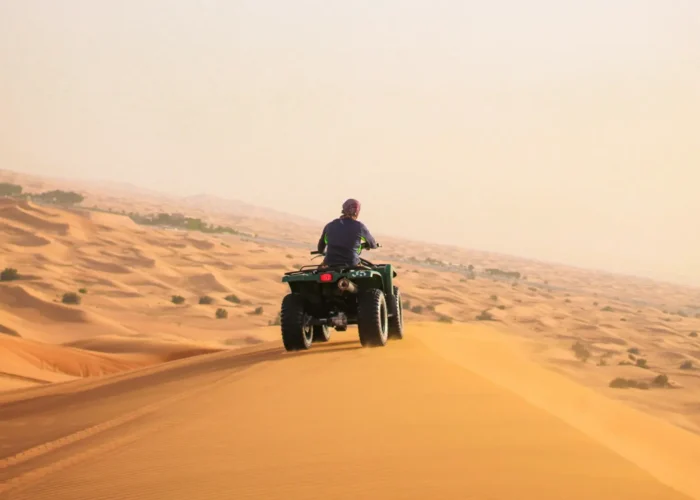 Quad bike riding over sand dunes