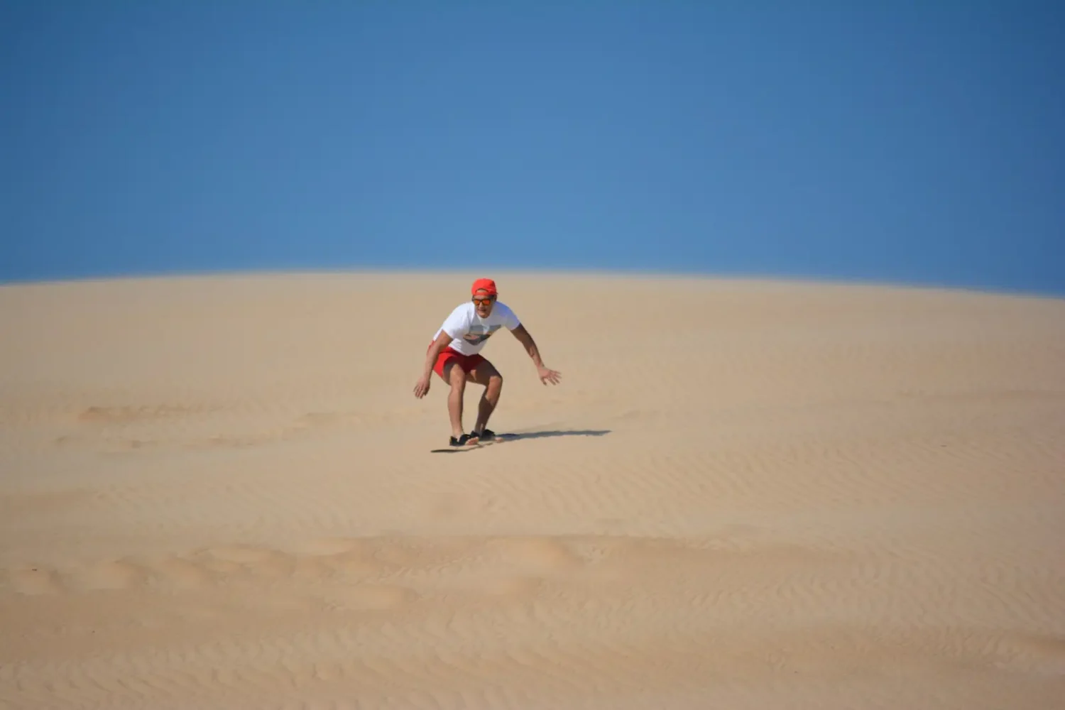 Sandboarding down a dune