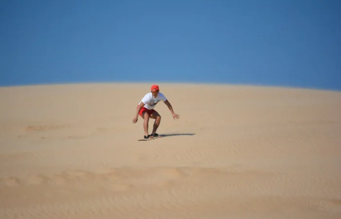 Sandboarding down a dune